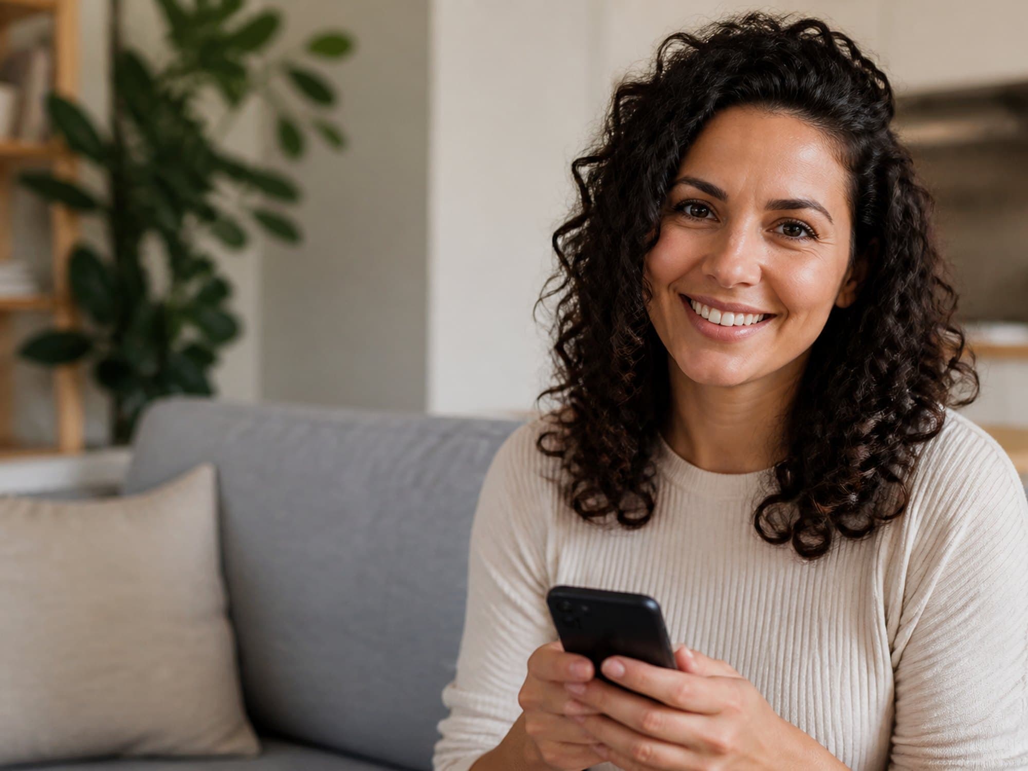 A woman smiling with a phone, ready to call about tirzepatide care