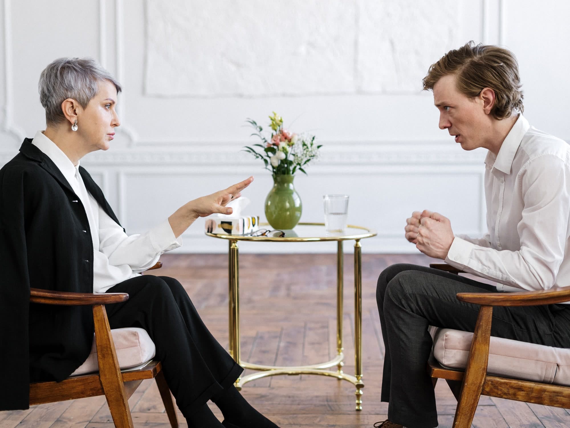 A clinician and an adult discussing a recovery plan across two chairs