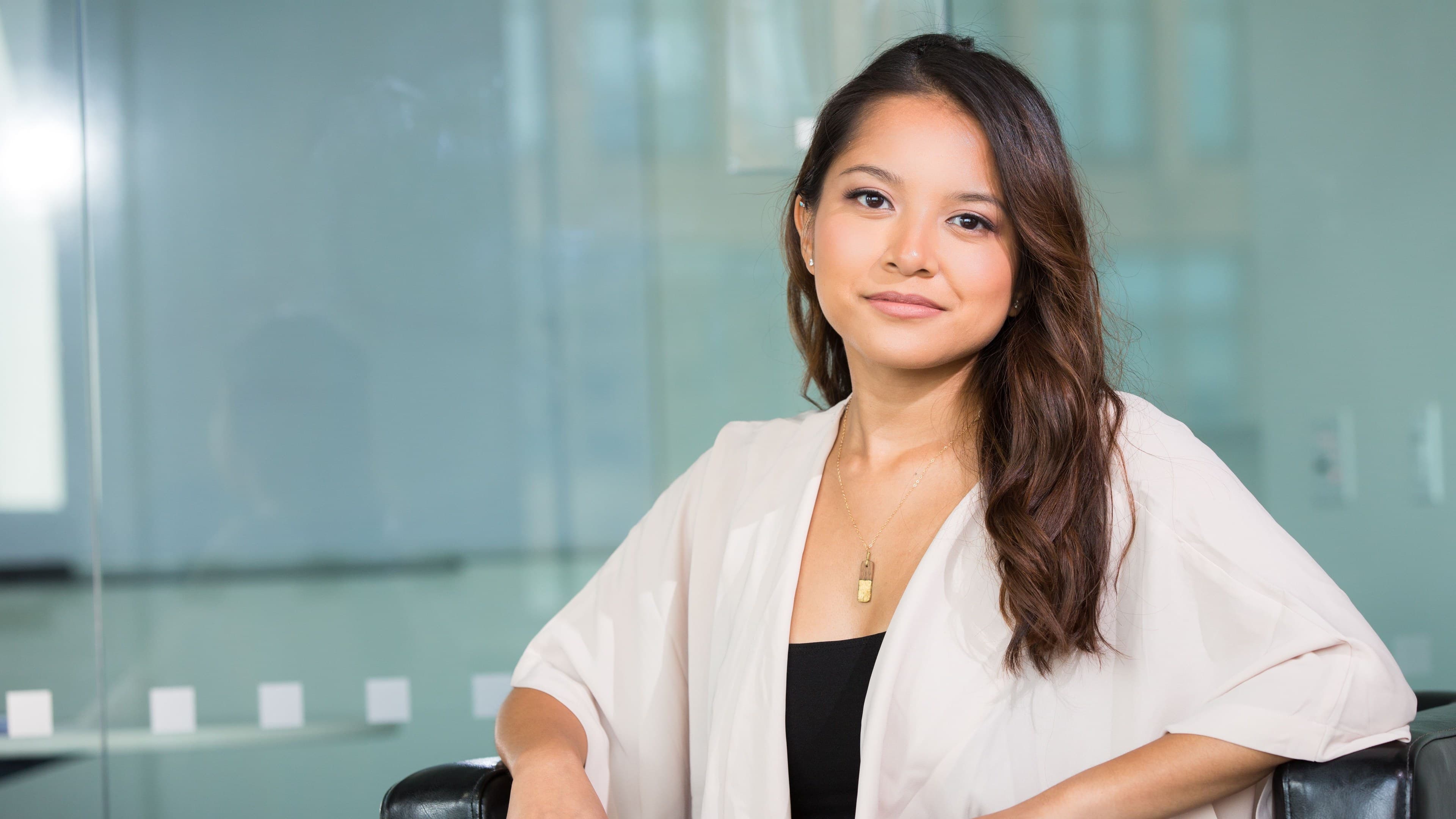 An Asian woman seated in a bright modern lounge