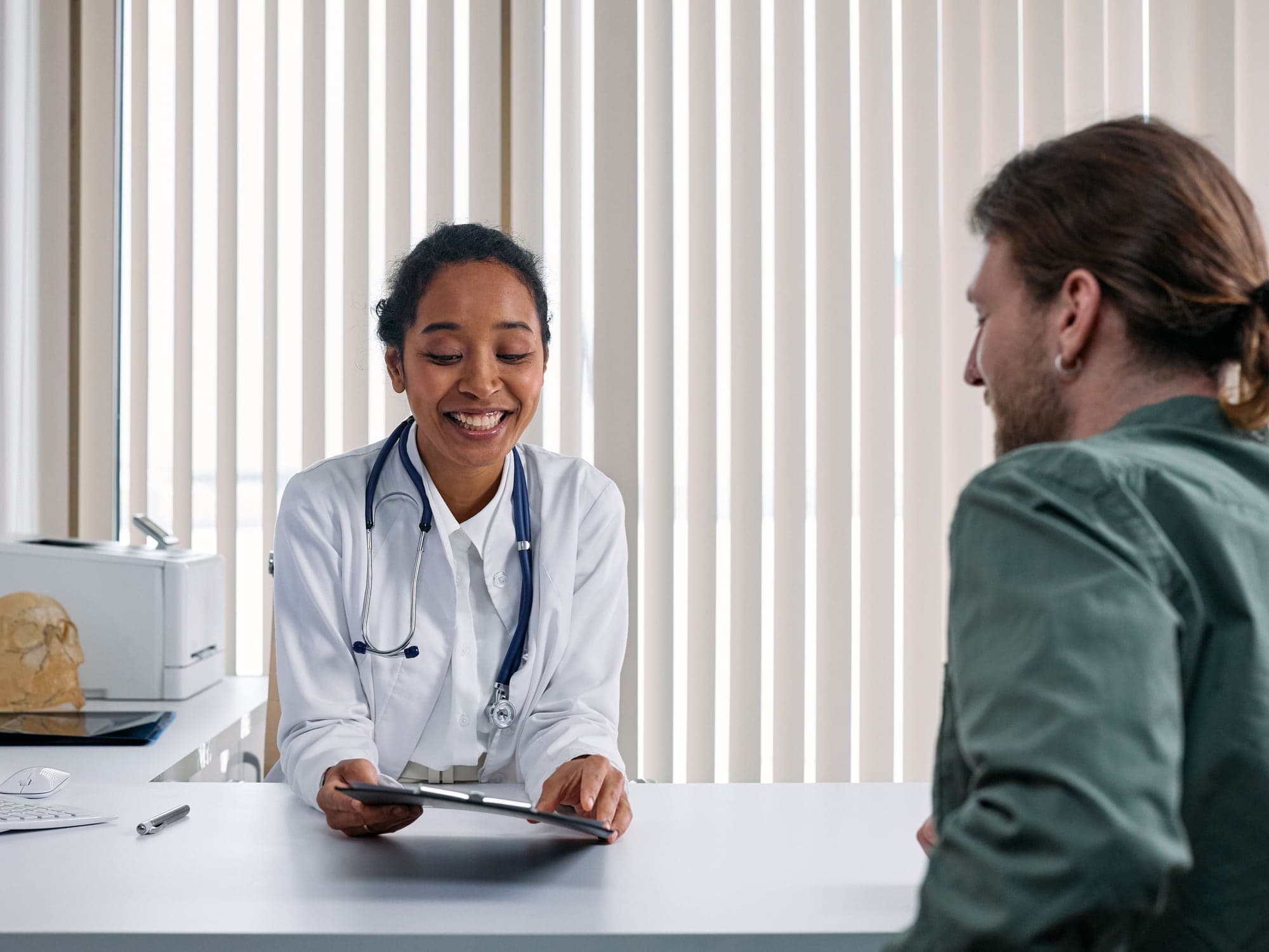 A clinician and a visitor reviewing information together across a table