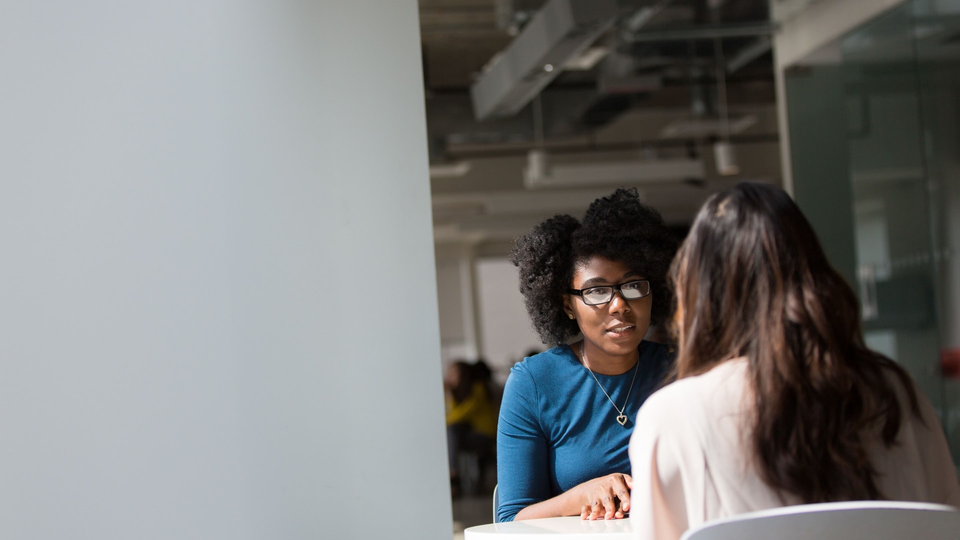 Two women discussing a care question across a small table