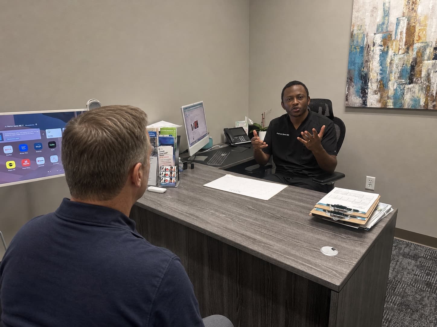 Dr. Patrick Oben speaking with a male visitor during a testosterone consultation at WellForm MD