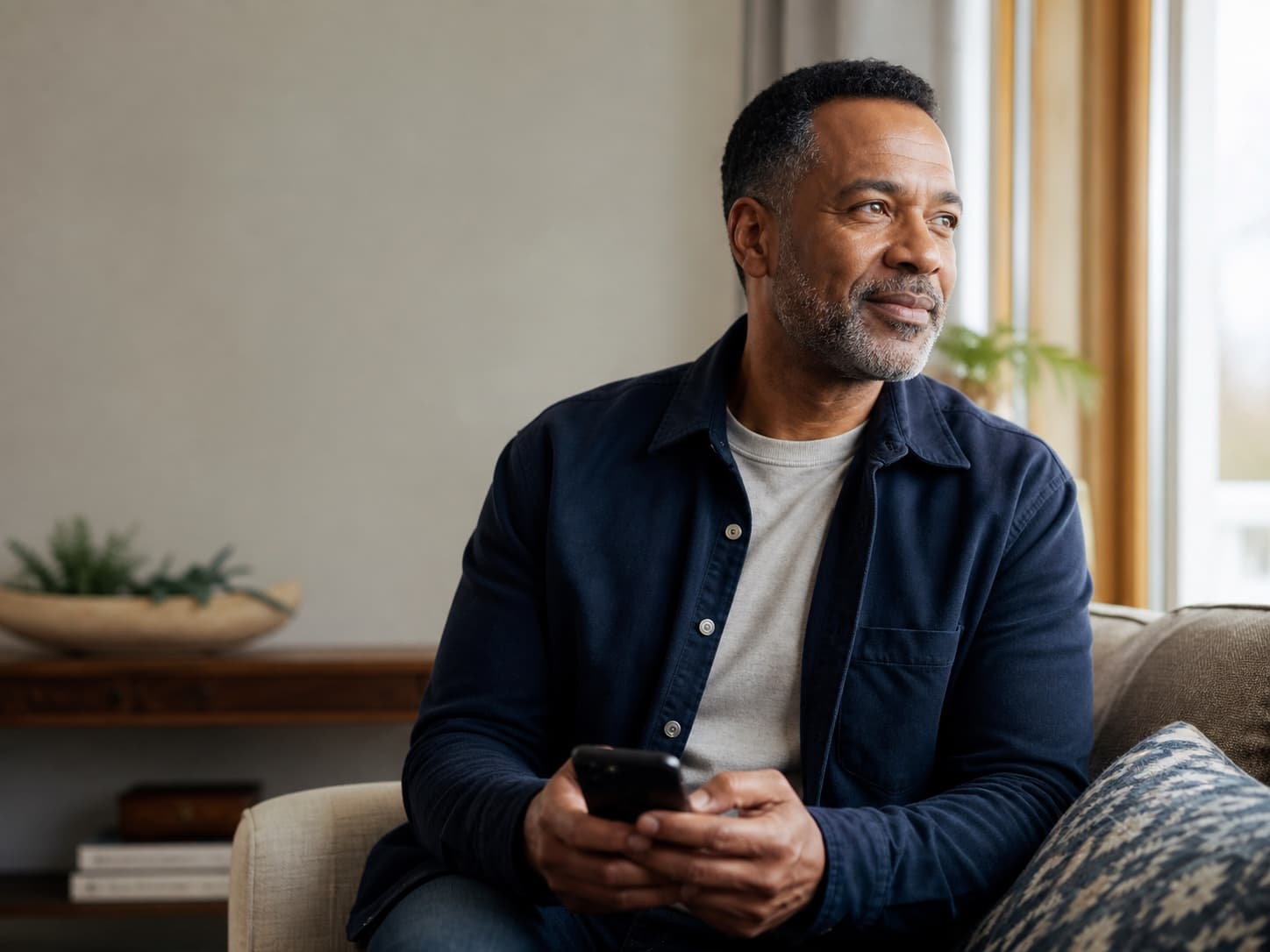 Illustrative midlife man holding his phone after requesting a consultation