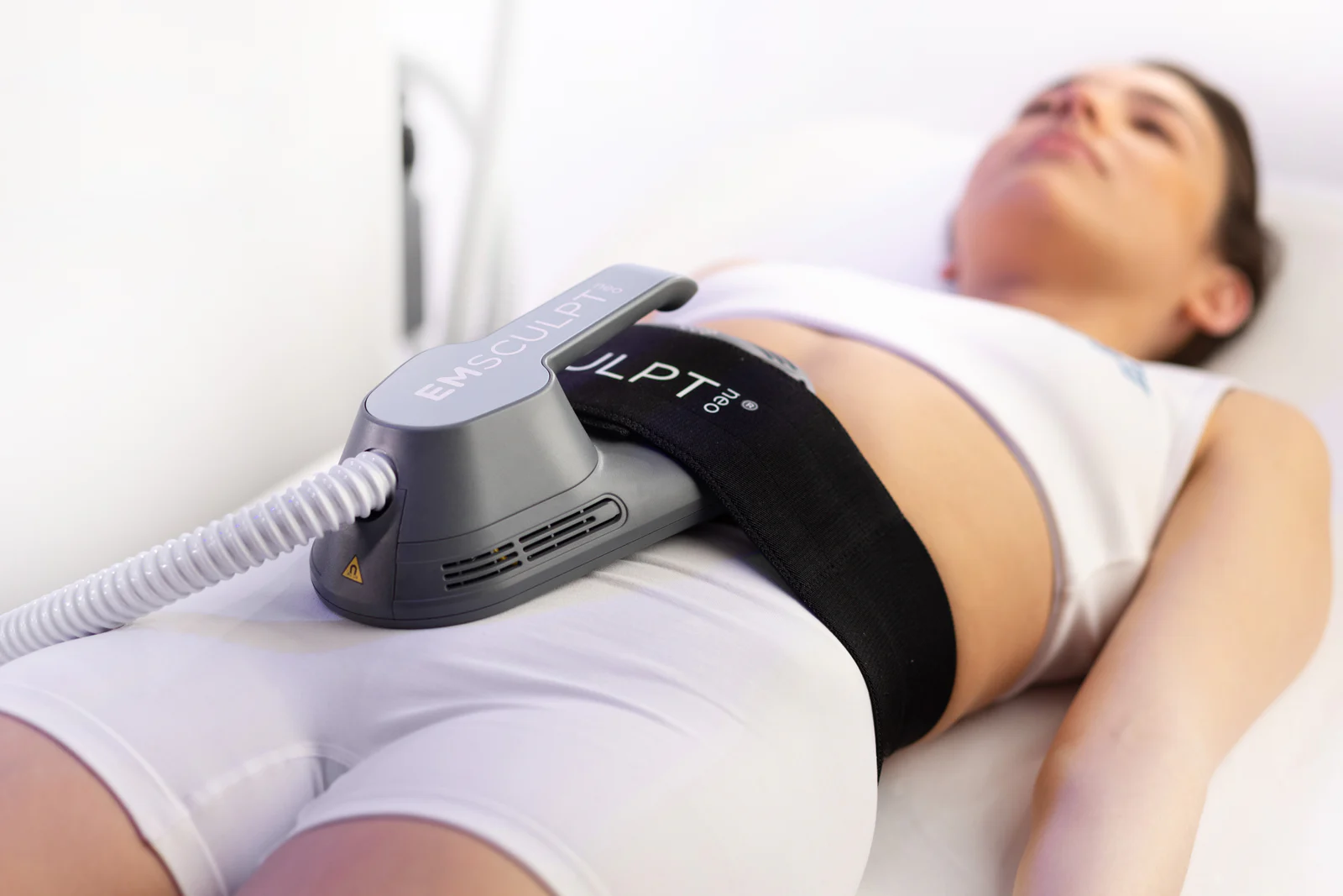 EMSCULPT NEO applicator secured over the abdomen during treatment