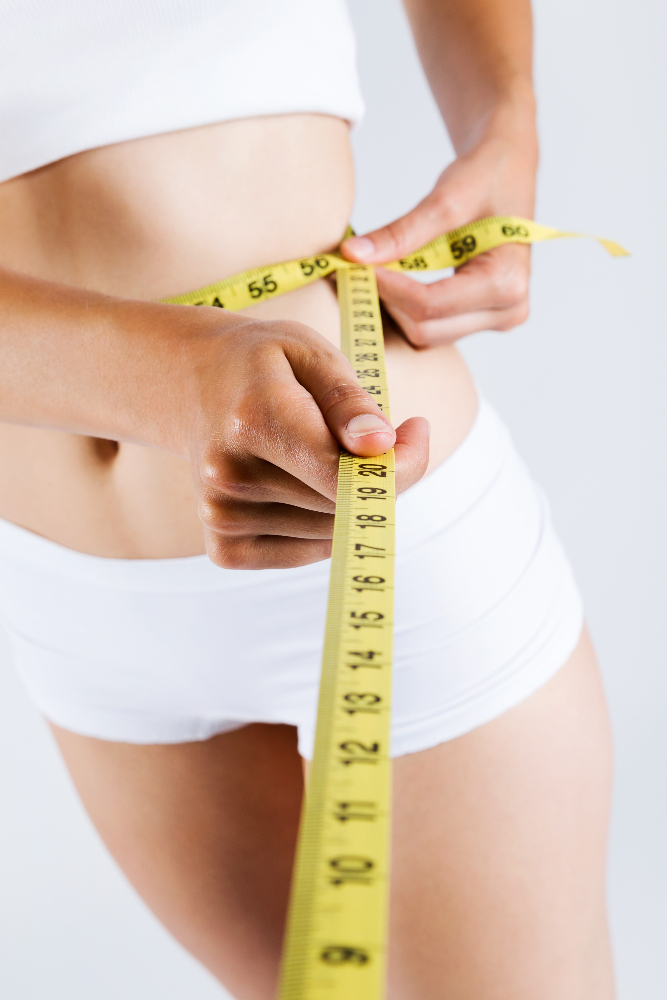 a woman measuring her waist