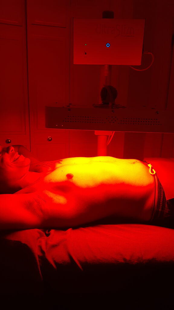 a man lying on a bed with red light